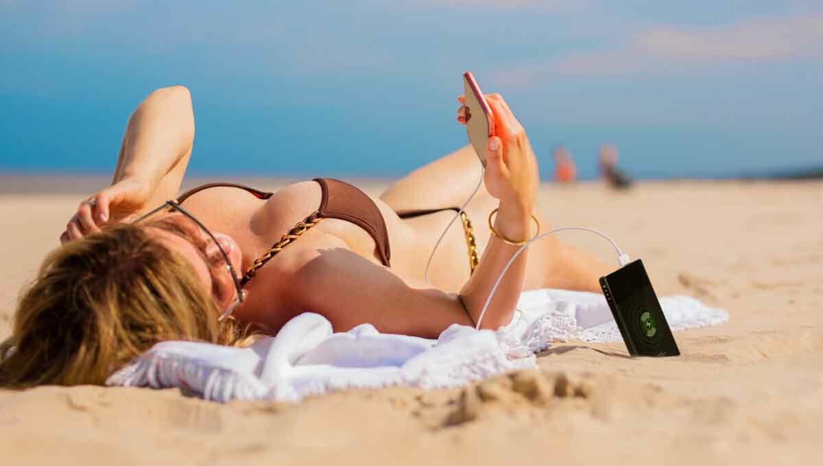 sexy woman on the beach with power bank